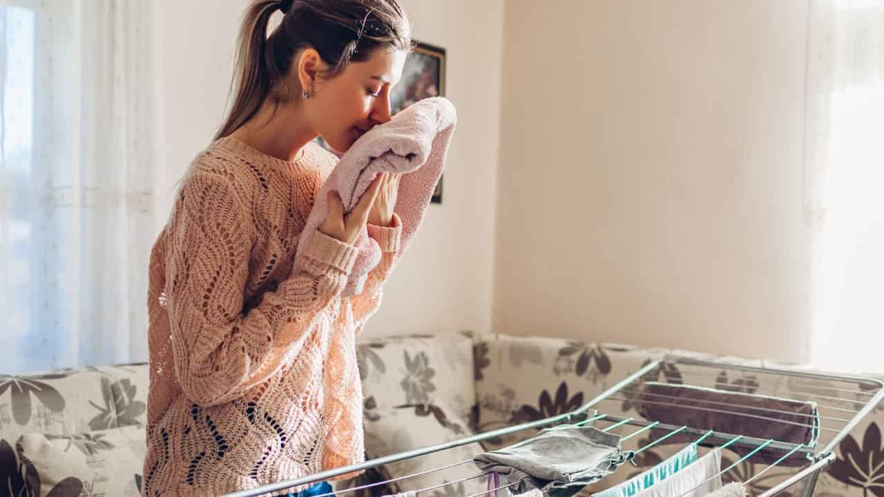La mujer huele ropa muy fragante